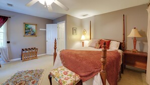 A bedroom with a bed, bedside tables, a nightstand, a ceiling fan, a door, and a window with curtains. - Group Getaway w/ Private Yard in Marietta (Marietta)