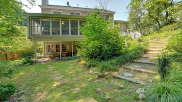 A two-story house with a covered patio and a stone staircase leading up to the entrance.