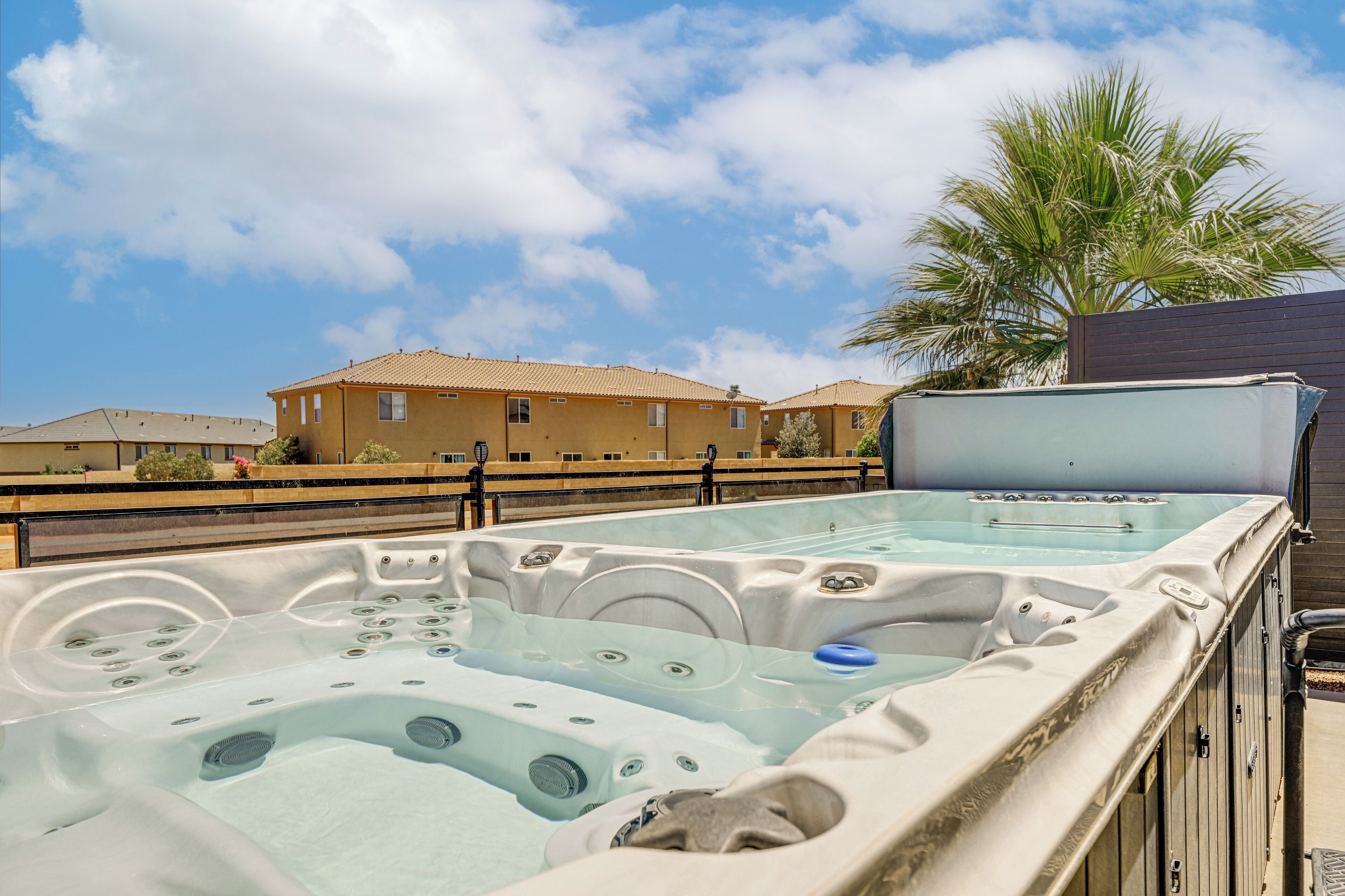 A hot tub area with a clear view of a residential building in the background.