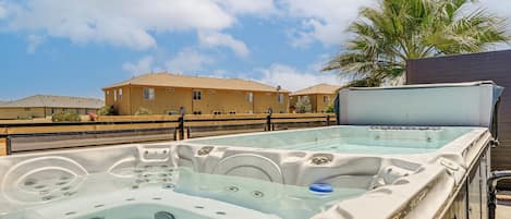 A hot tub area with a clear view of a residential building in the background.