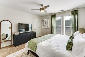 A bedroom with a bed, dresser, television, and a ceiling fan. - Walk to Cleveland Clinic! Contemporary Townhome (Cleveland)