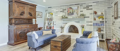 A living room with a fireplace, a bookshelf, and a large wooden cabinet.