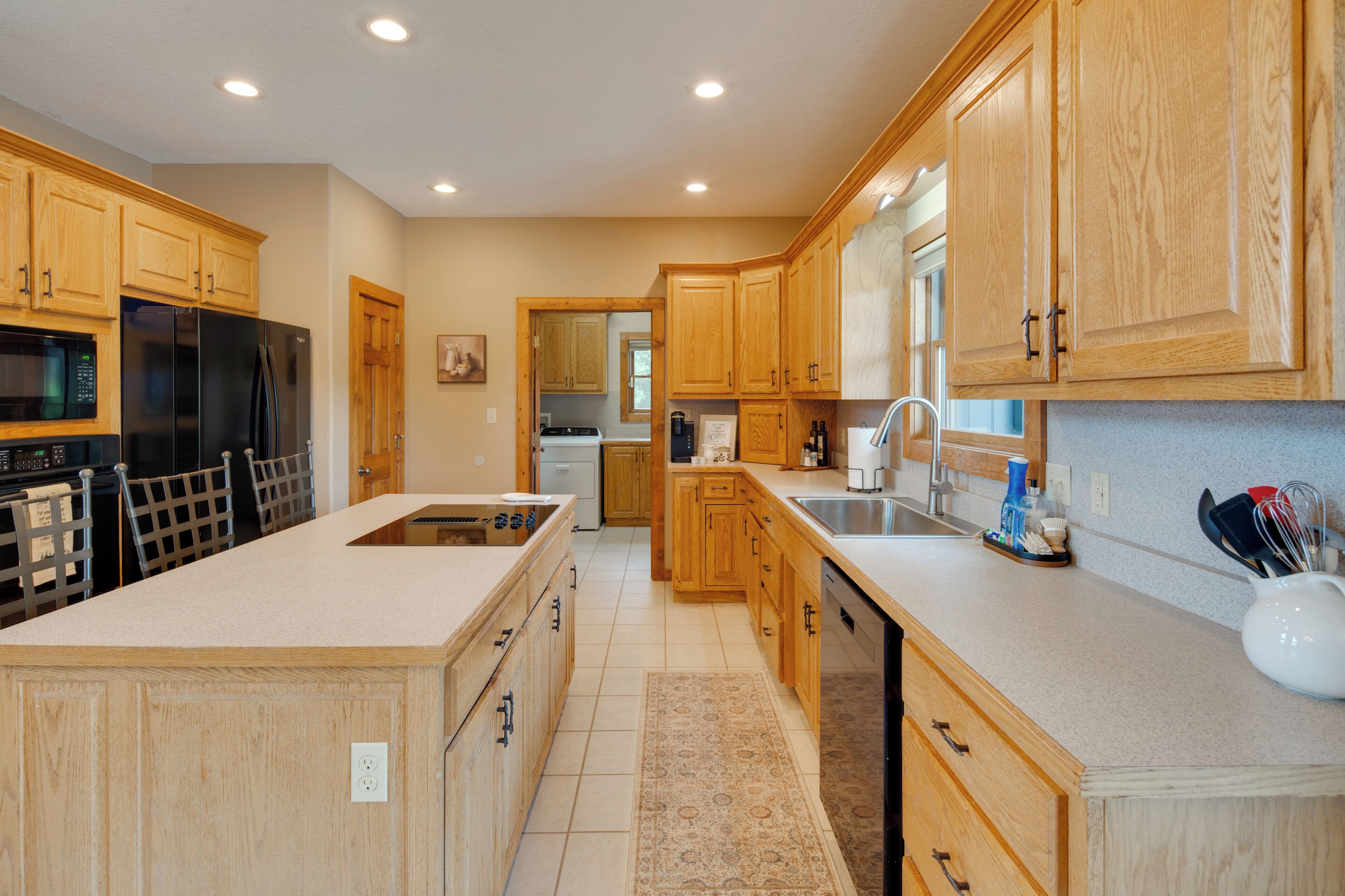 A modern kitchen with wooden cabinets, stainless steel appliances, and a large island.