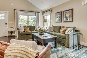 A living room with a sofa, a coffee table, a patterned rug, and two framed pictures on the wall. - Walk to Dtwn Waynesville! Dual Mtn Havens w/ Decks (Waynesville)