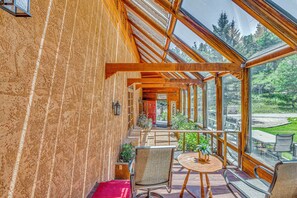 A covered outdoor area with wooden beams, a red carpet, and a view of a forest. - Hike & Ski! Quiet Home w/ Solarium in Cloudcroft (Cloudcroft)