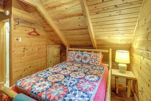 A wooden room with a bed, a hanging coat rack, and a lamp. - Rustic Cabin w/ Phoenix Mtn Views & Trail Access! (Lansing)