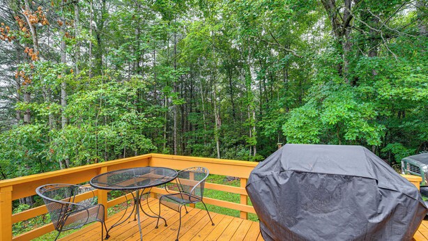 A wooden deck with a covered grill and metal tables and chairs. - Rustic Cabin w/ Phoenix Mtn Views & Trail Access! (Lansing)