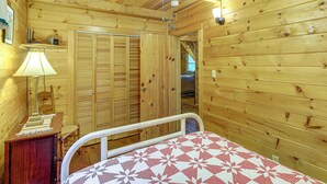 A wooden interior with a bed, a nightstand, a lamp, and a ceiling fan. - Rustic Cabin w/ Phoenix Mtn Views & Trail Access! (Lansing)