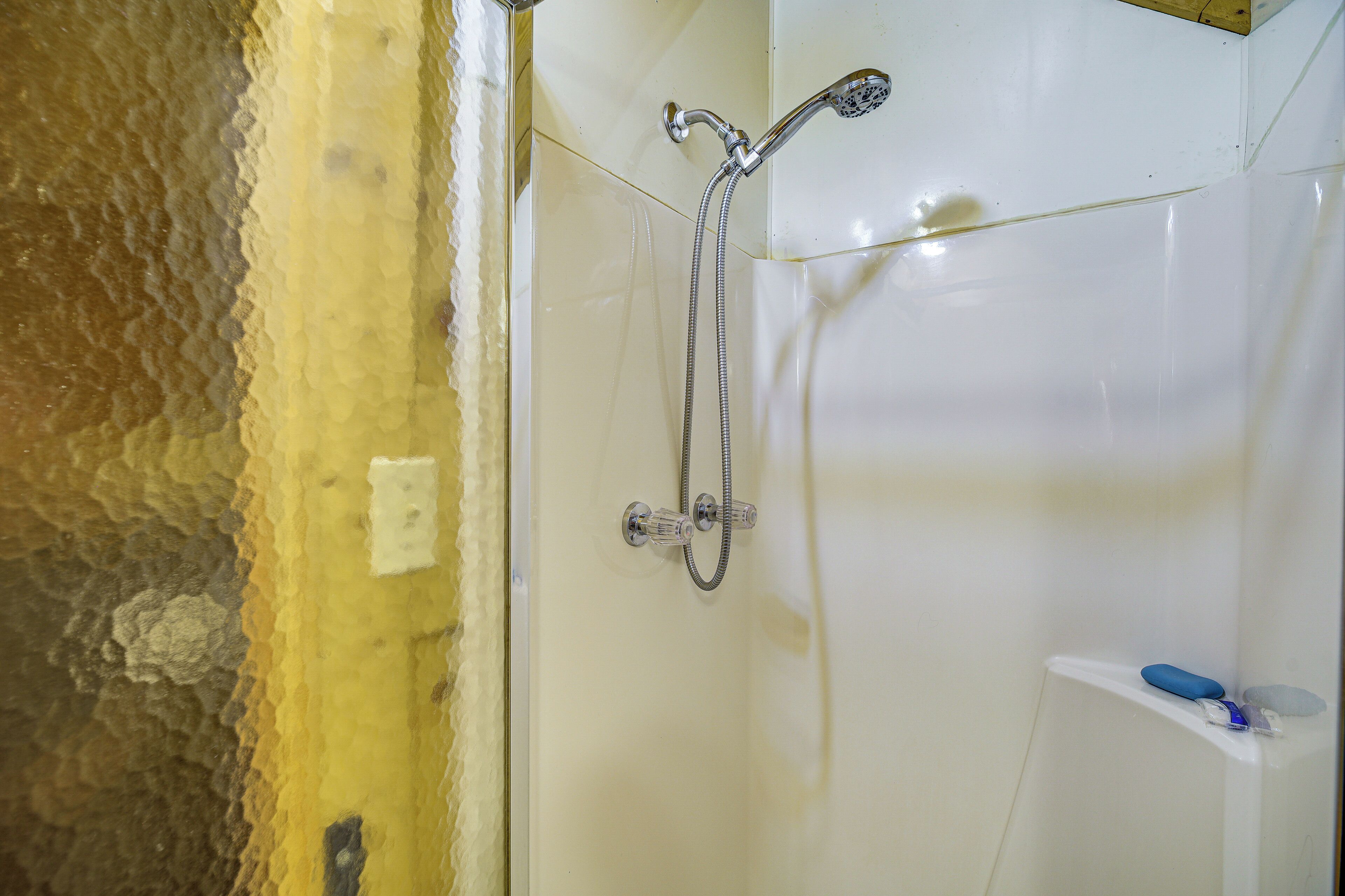 A bathroom with a shower, a toilet, and a sink.