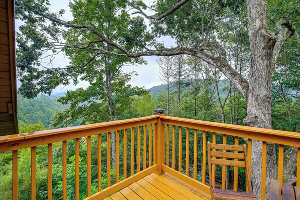 A wooden deck with a railing overlooking a forested area. - Rustic Cabin w/ Phoenix Mtn Views & Trail Access! (Lansing)