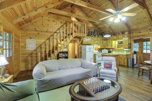 A cozy cabin interior with a wooden ceiling, a sofa, a chair, a dining table, and a kitchen area. - Rustic Cabin w/ Phoenix Mtn Views & Trail Access! (Lansing)