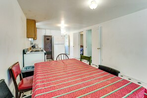 Ein Schlafzimmer mit einem Bett, einem Schreibtisch, einem Stuhl und einem Kleiderschrank.