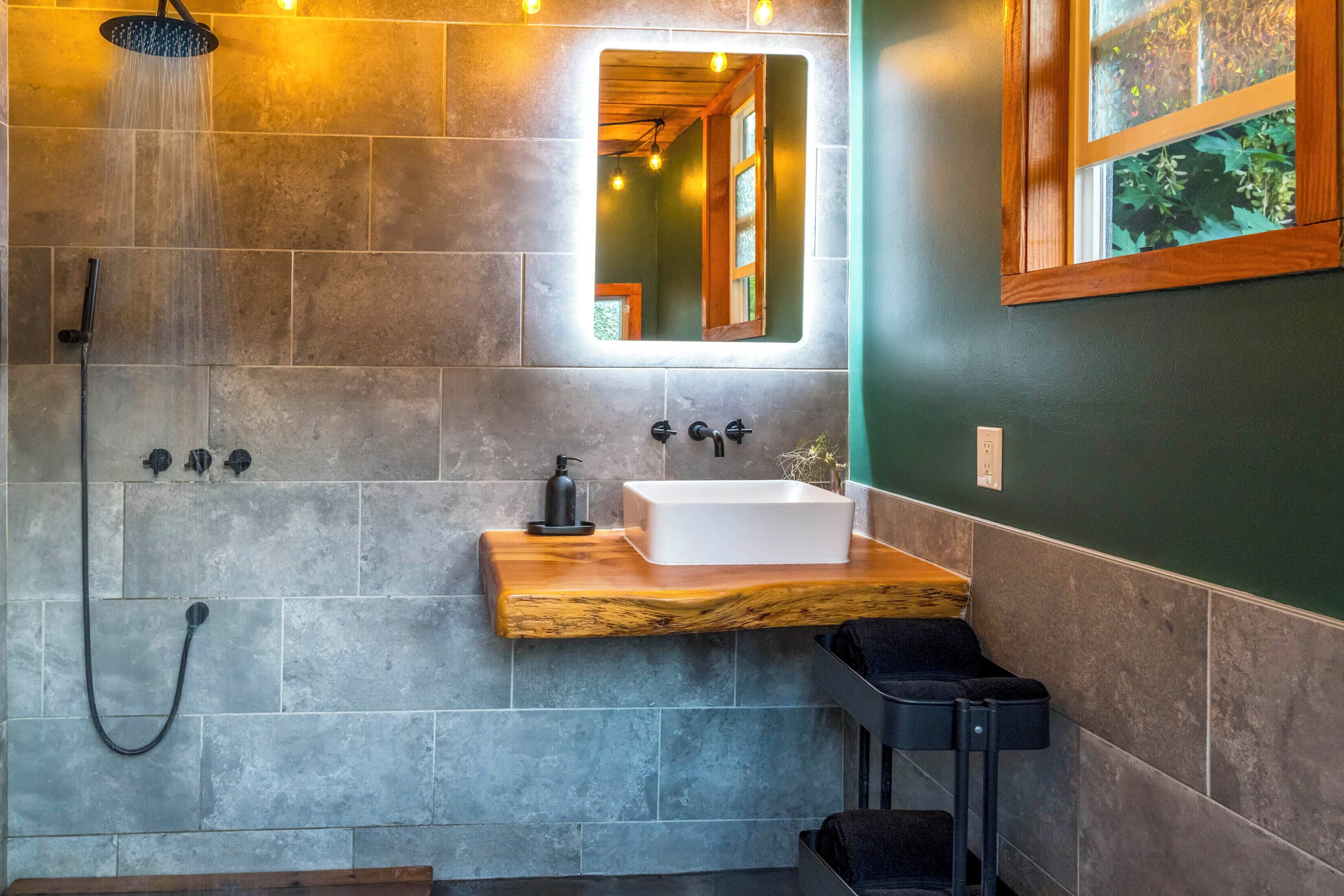 A bathroom with a shower, a sink, and a mirror.