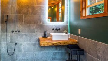 A bathroom with a shower, a sink, and a mirror.