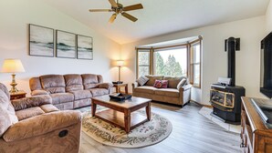 A living room with a sofa, armchair, coffee table, and a fireplace. - Lake Roosevelt Retreat Lake: Mtn Views, Game Room (Davenport)