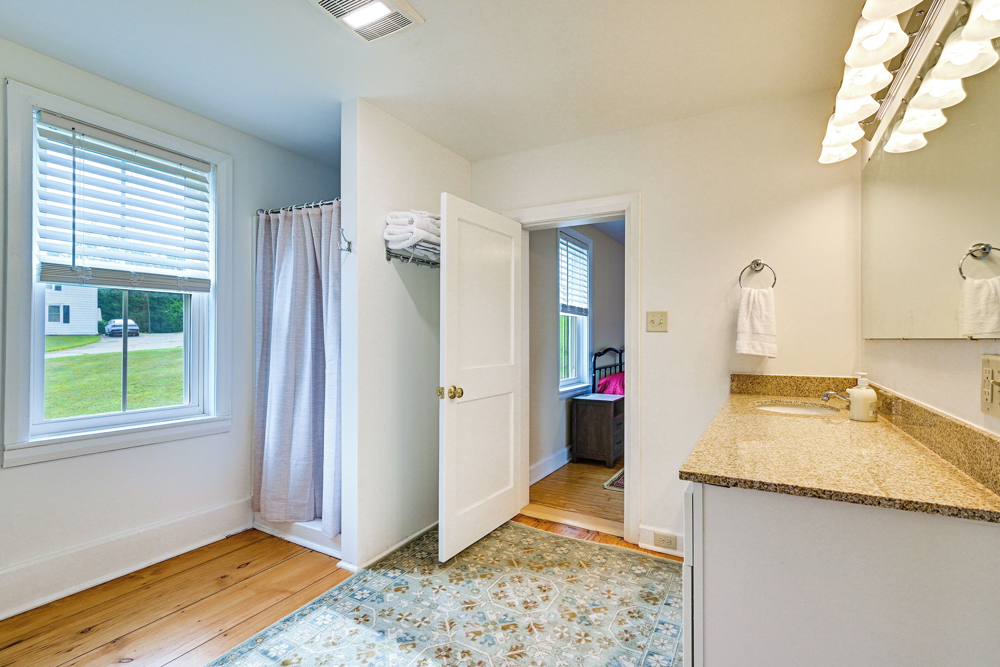 A bathroom with a shower, a sink, and a mirror.