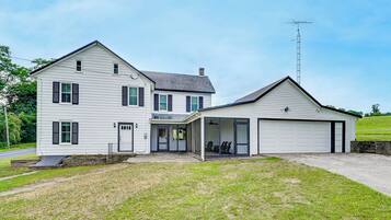 A two-story house with a garage and a covered porch.