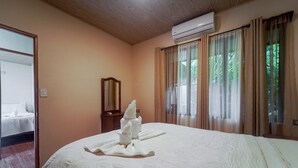 A hotel room with a bed, a mirror, an air conditioner, and curtains. - Home w/ Surrounding Lake Arenal & Volcano Views! (Peñas Blancas)