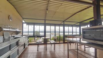 A kitchen with a view of a lake, a dining area with tables and chairs, and a large window.
