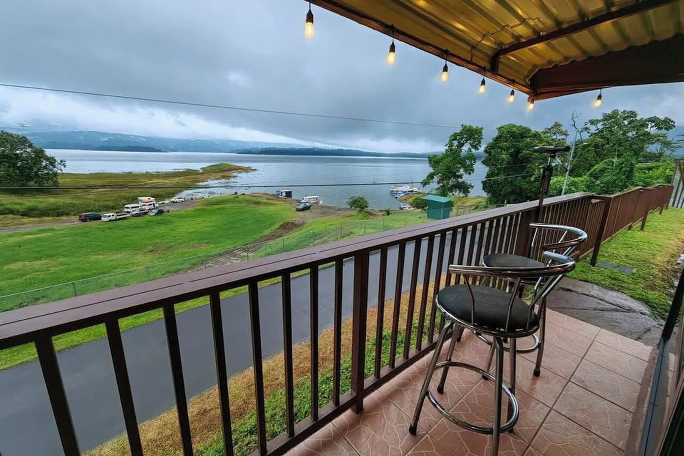 Un balcon donnant sur un lac, avec une chaise et une table.