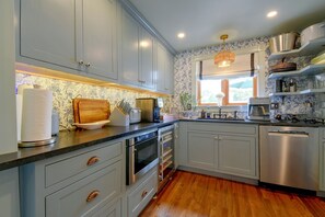 A kitchen with grey cabinets, a wooden countertop, and a window with a view. - Aisling House - Historic Hospitality (Winchester)