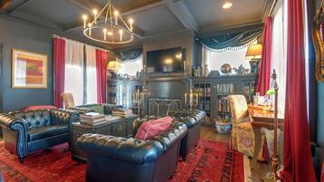 A traditional living room with leather sofas, a fireplace, and a television.