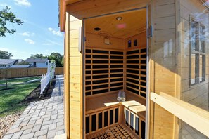 A wooden sauna with a sloped ceiling, a bench, and a towel on the floor. - Aisling House - Historic Hospitality (Winchester)