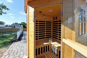 Una sauna de madera con techo inclinado, un banco y una toalla en el suelo.