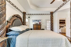 Une chambre à coucher avec un grand lit, une commode et un tableau accroché au mur.