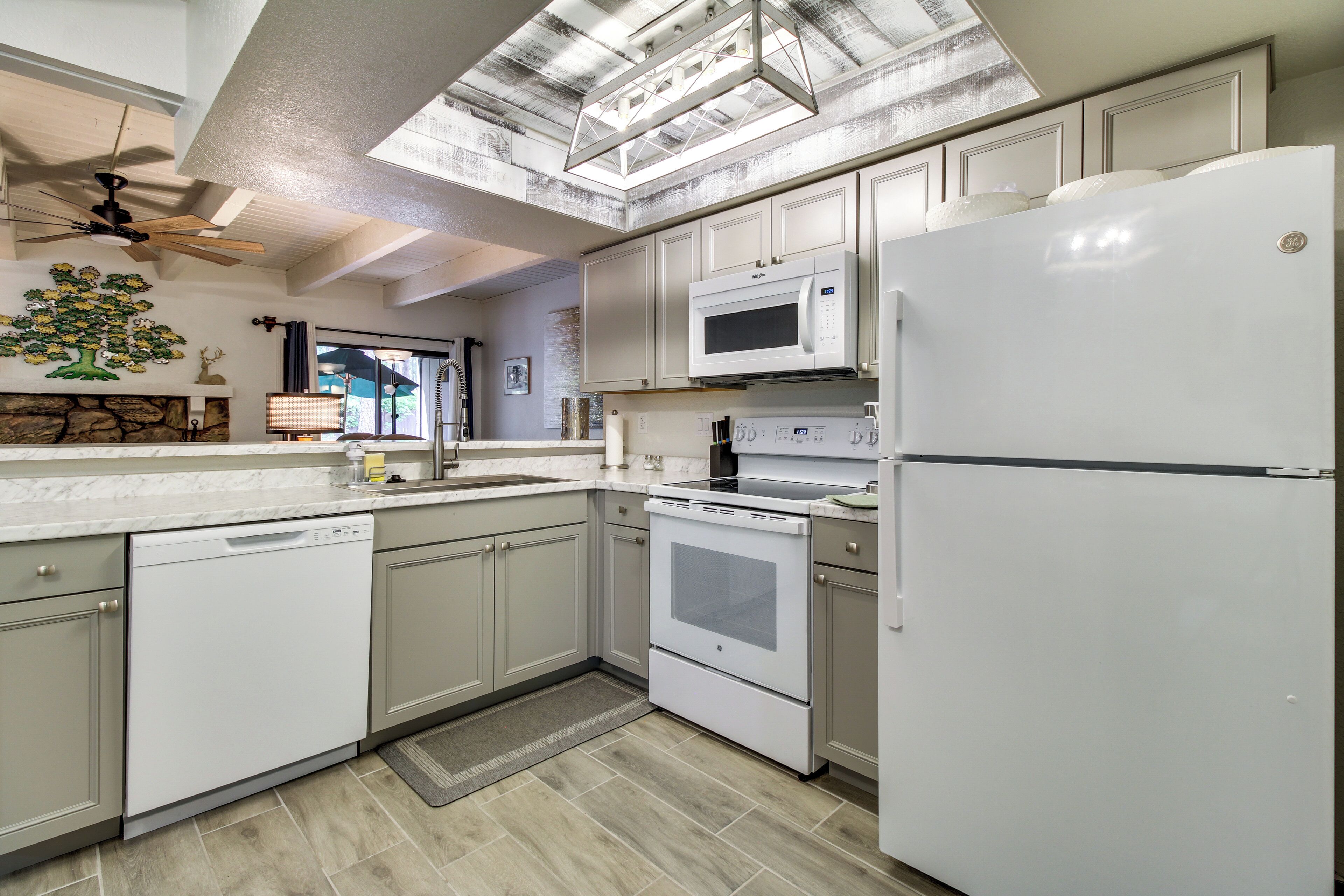 A modern kitchen with white appliances, a dishwasher, an oven, and a refrigerator.