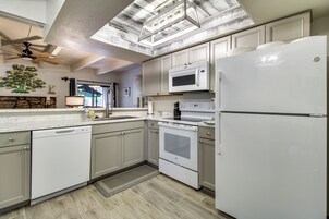 A modern kitchen with white appliances, a dishwasher, an oven, and a refrigerator.