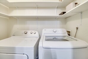 A laundry room with two white washers and dryers, a shelf above, and a power outlet on the wall. - Great for Families! Pinetop Sanctuary w/ Patio (Pinetop)
