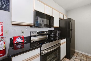 Eine Küche mit Mikrowelle, Backofen und Kühlschrank.