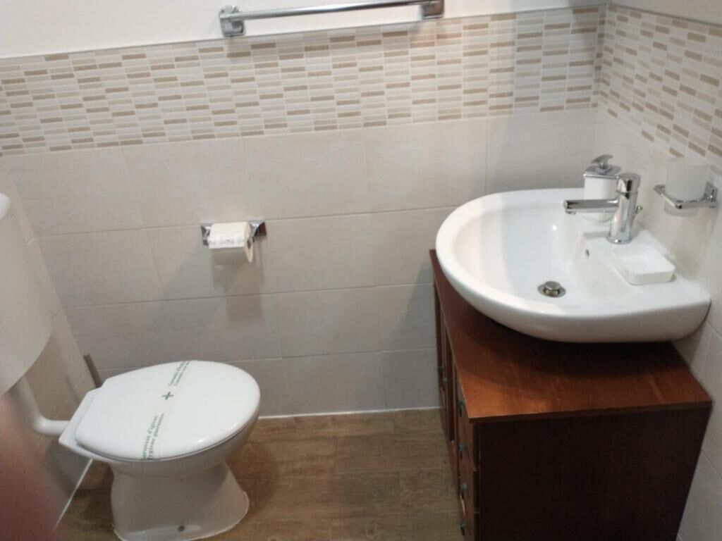 A bathroom with a toilet, a sink, and a mirror.