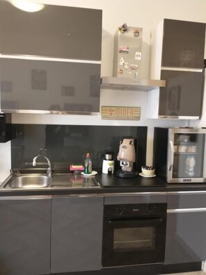 A modern kitchen with a dishwasher, oven, and a microwave. - B&B DALLA ZIA (Bari)