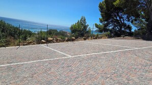 A paved outdoor area with a view of the sea, surrounded by trees and a fence. - Nice apartment in villa with WIFI, A/C, TV, patio and panoramic view, close to Imperia (San Bartolomeo Al Mare)
