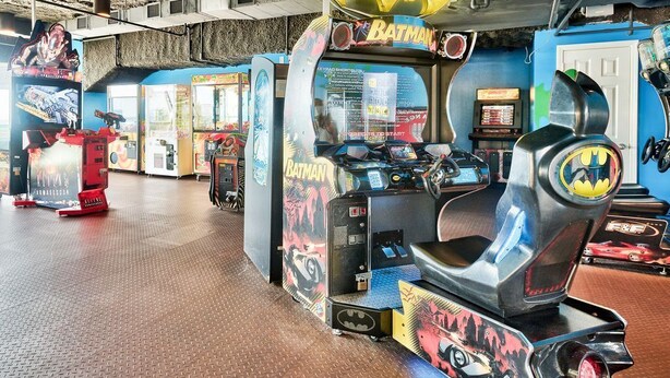 Un’area giochi con diverse macchine da gioco, tra cui una a tema Batman.