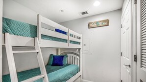 Una camera con un letto a castello, una porta e un cartello appeso al muro.