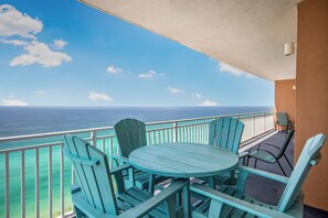 Un balcon avec une table et des chaises, donnant sur une étendue d’eau.