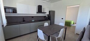 Een kleine keuken met een eethoek, een koelkast en een spoelbak.