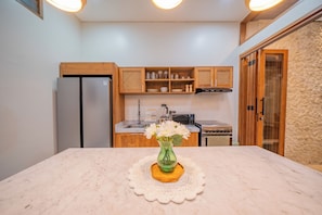 A kitchen with a marble countertop, a refrigerator, wooden cabinets, and a stove. - 3BR Umalas Villa • Pool & Rooftop Terrace • Scooter & Restaurant discounts (Kuta Utara)