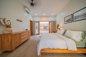 Un dormitorio con cama, cómoda de madera y vistas a un balcón.