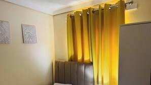 A hotel room with a bed, a bedside lamp, and a curtain. - Room-home for Contractors and Tourists (Salford)