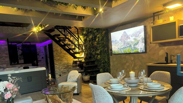 A modern dining area with a round table set for four, surrounded by grey upholstered chairs. - Cozy 1-bedroom house in fantastic Rosult with AC (Rosult)