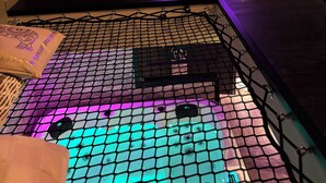 A cozy room with a sloped ceiling, a bean bag chair, a small table with a vase, and a netted area in the foreground. - Cozy 1-bedroom house in fantastic Rosult with AC (Rosult)
