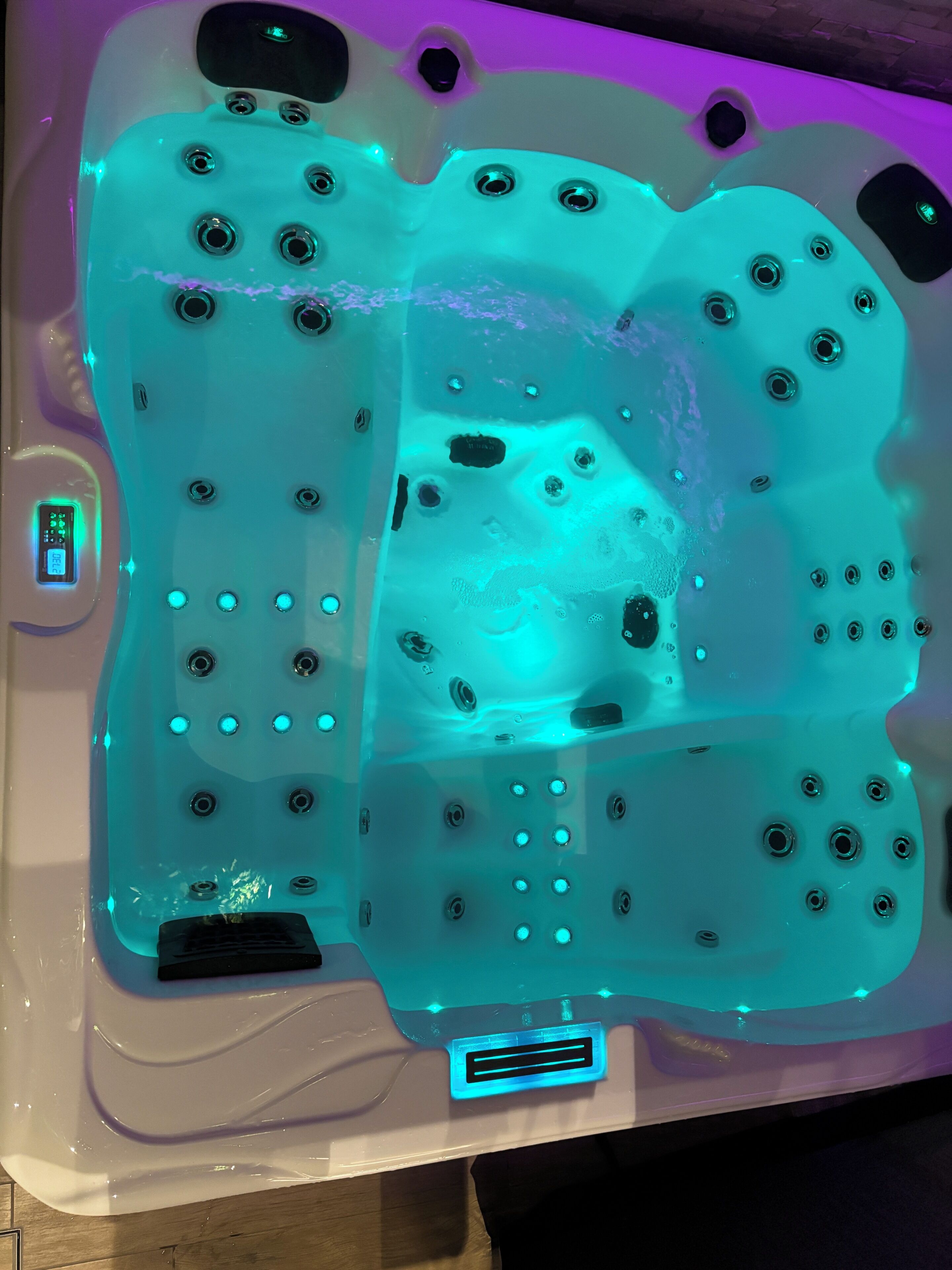 A hot tub with multiple jets, a control panel, and a digital display.