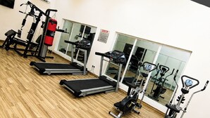 Un gimnasio con cintas de correr, máquinas de pesas y un saco de boxeo.