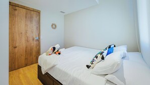 Habitación de hotel con armario de madera, cama con ropa de cama blanca y un espejo decorativo en la pared.