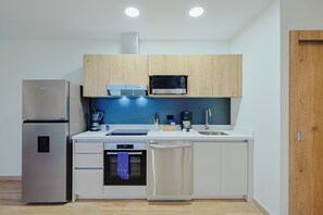 A compact kitchen with a refrigerator, microwave, oven, and dishwasher. - Bonsai 1BR Suite-Bamboo 206 (Noord)