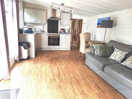 Un espacio habitable compacto con kitchenette, zona de comedor y sala de estar.